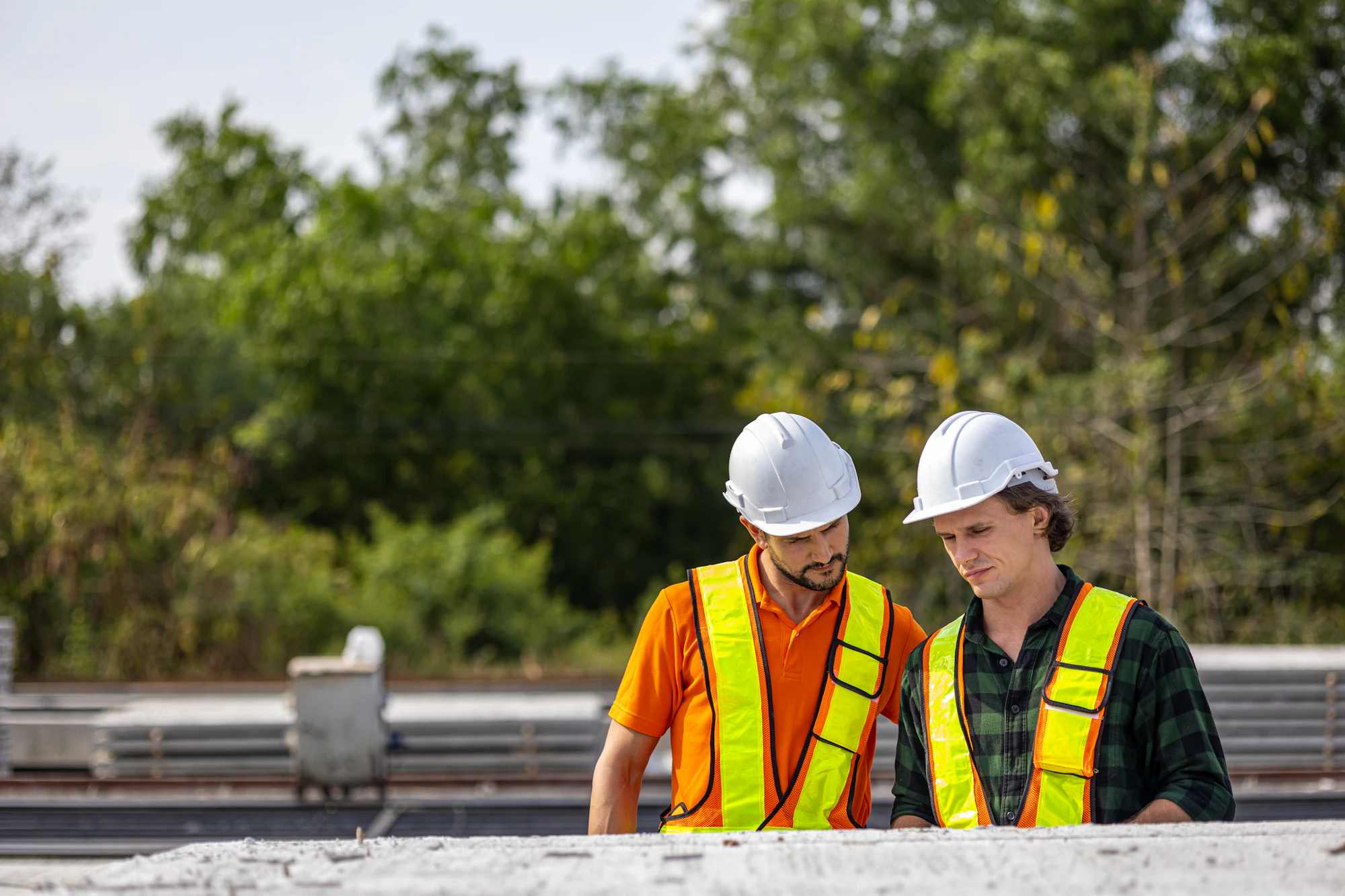 Construction workers reviewing plans inside an industrial facility