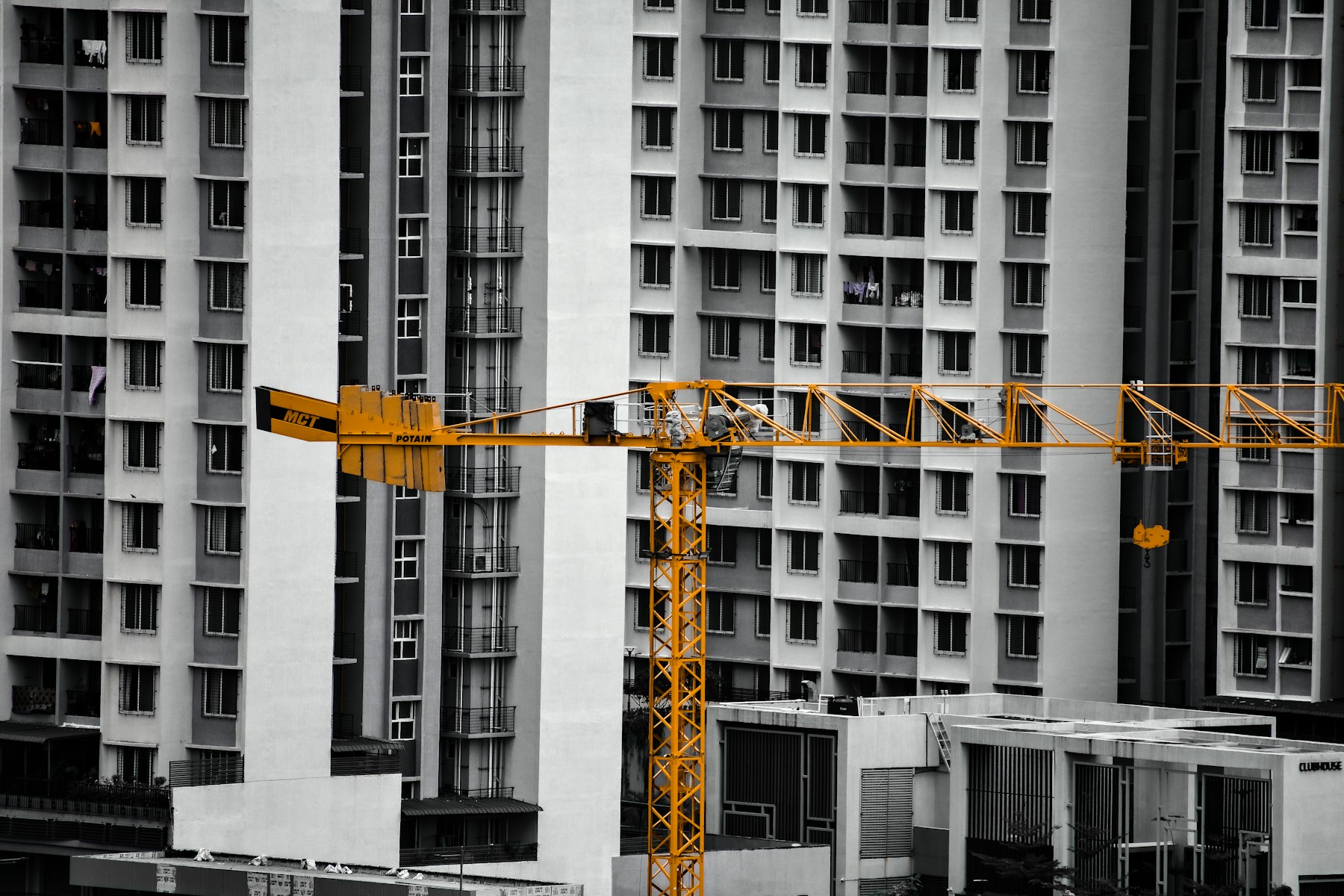Yellow construction crane in front of apartment buildings